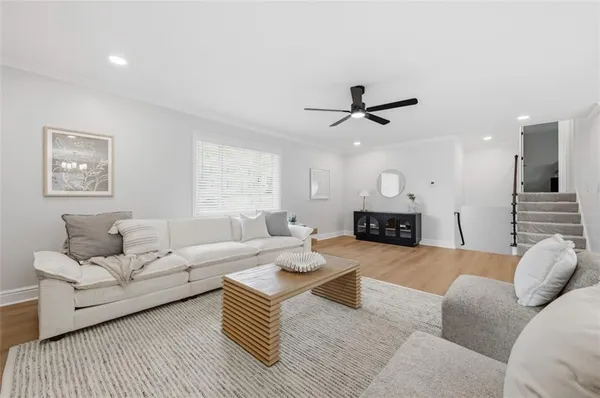 a living room with furniture a fireplace and a ceiling fan