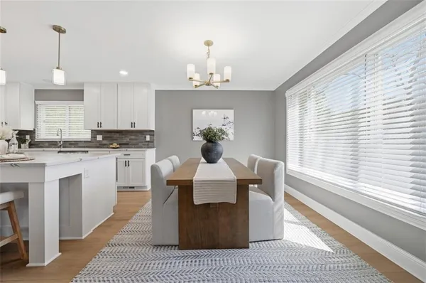a kitchen with stainless steel appliances a kitchen island a stove a table and chairs