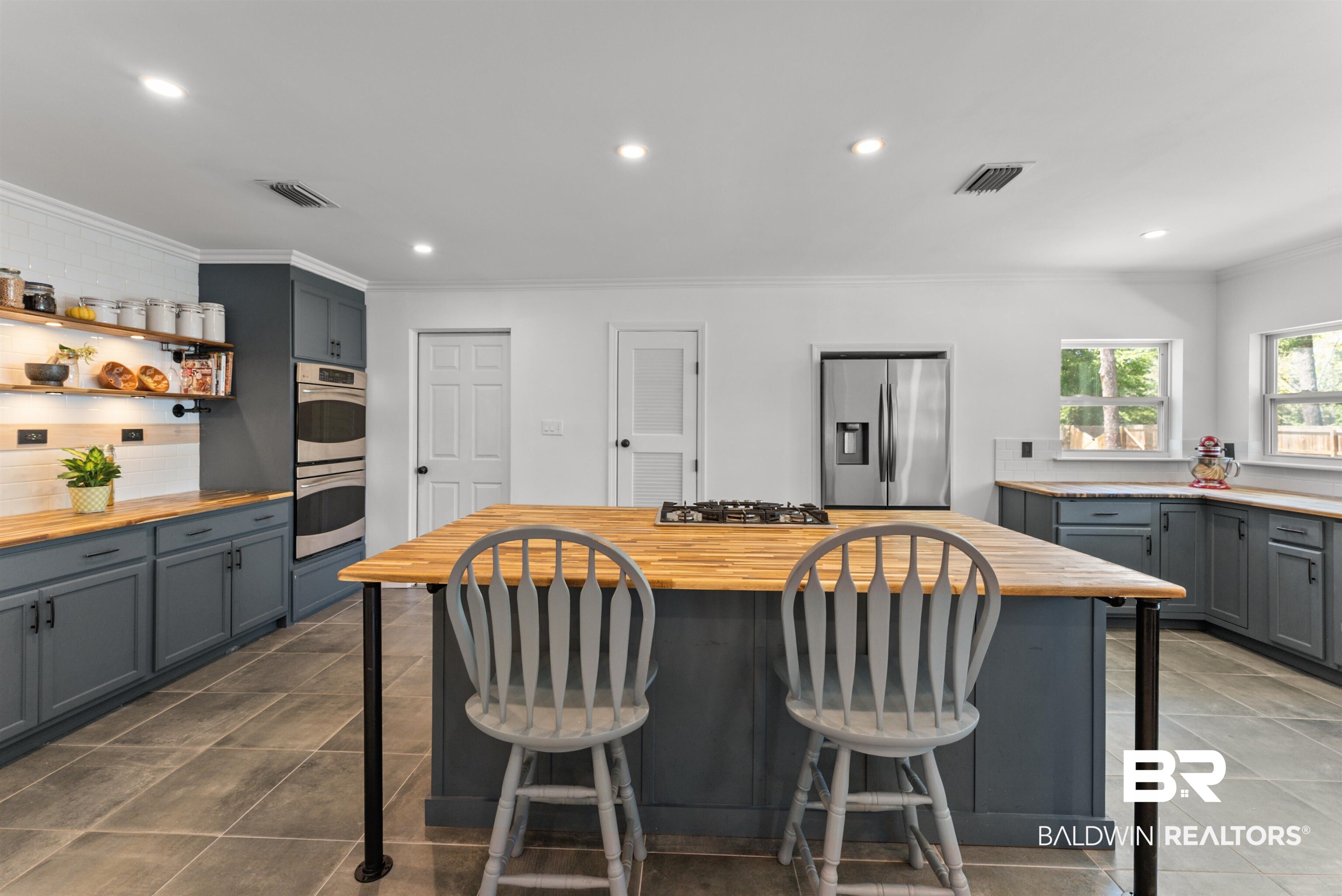 6447 Bemis Lane Bon Secour, AL 36511 - Photo 12 of 62 Kitchen featuring a central island with a gas cooktop, wood-finish countertops, extensive gray cabinetry, stainless steel double wall ovens, and a side-by-side refrigerator