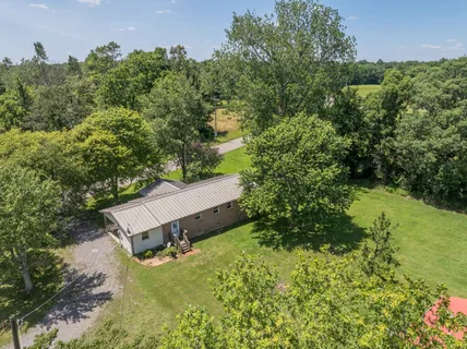 an aerial view of a house with a yard and lake view