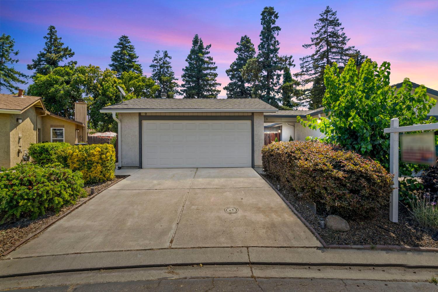 1296 Spruce Lane, Unit 9 Manteca, CA 95336 - Photo 1 of 1 a front view of a house with a yard and garage