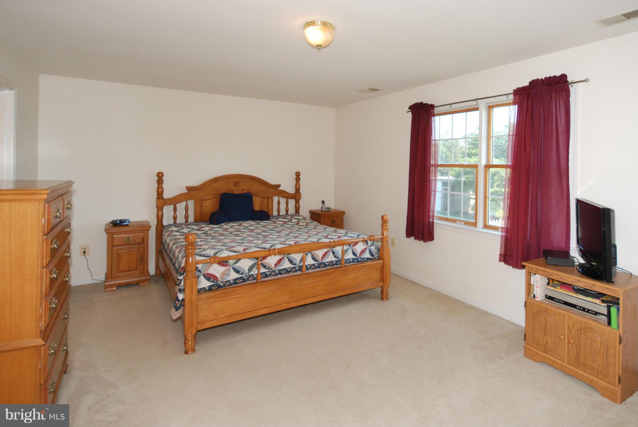 2118 Laurel Grove Road Winchester, VA 22602 - Photo 16 of 29 a bedroom with a bed and a flat tv screen on dresser