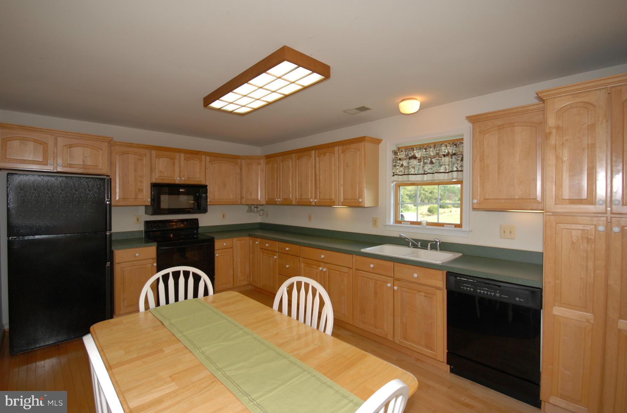 2118 Laurel Grove Road Winchester, VA 22602 - Photo 9 of 29 a kitchen with stainless steel appliances granite countertop a refrigerator a sink a stove a dining table and chairs with wooden floor