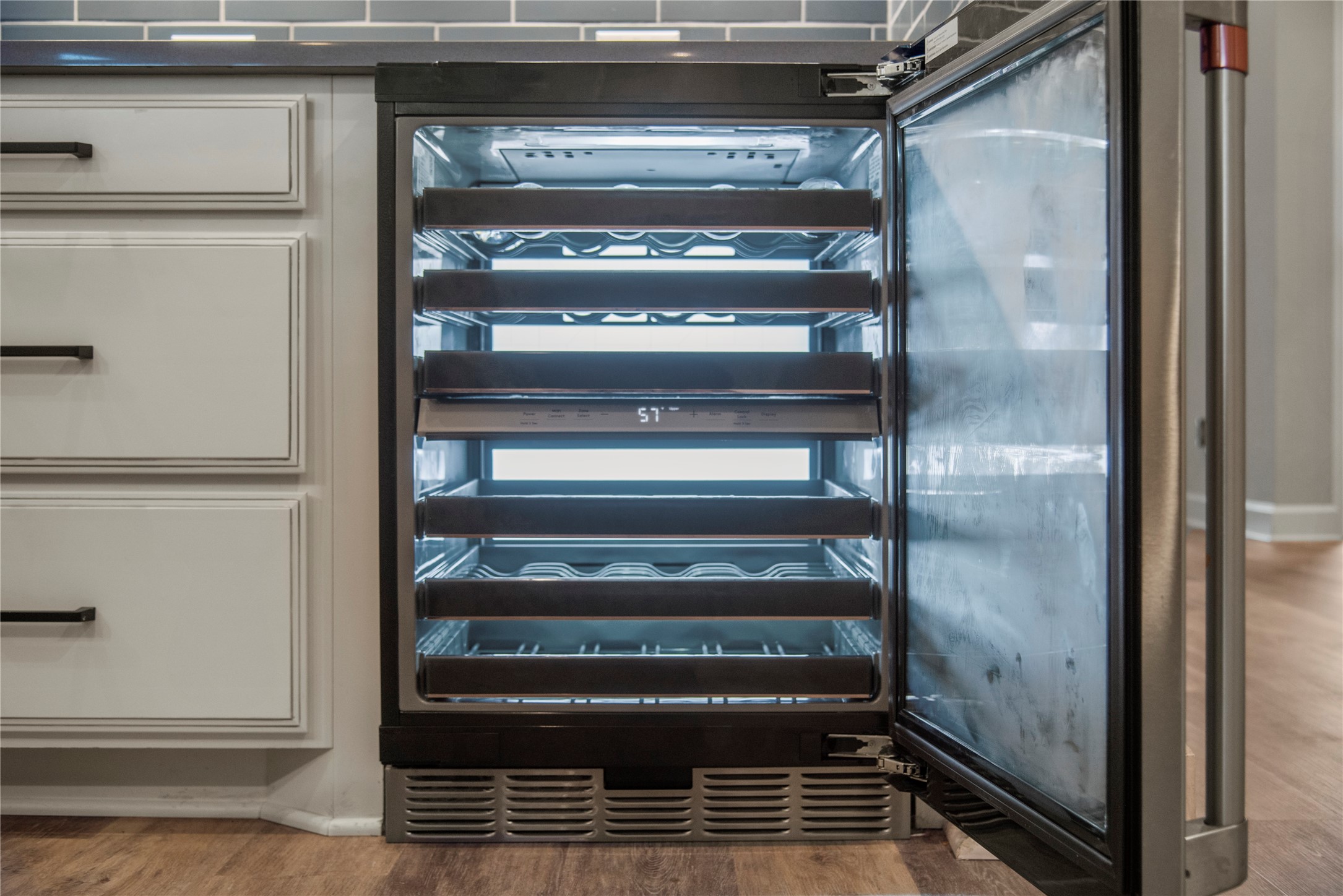 3438 Rich Radish Road Richmond, TX 77406 - Photo 7 of 25 A closer look at the upscale kitchen amenities reveals the integrated premium GE Café wine center, beautifully built into the cabinetry with digital temperature controls and accent lighting for seamless entertaining.
