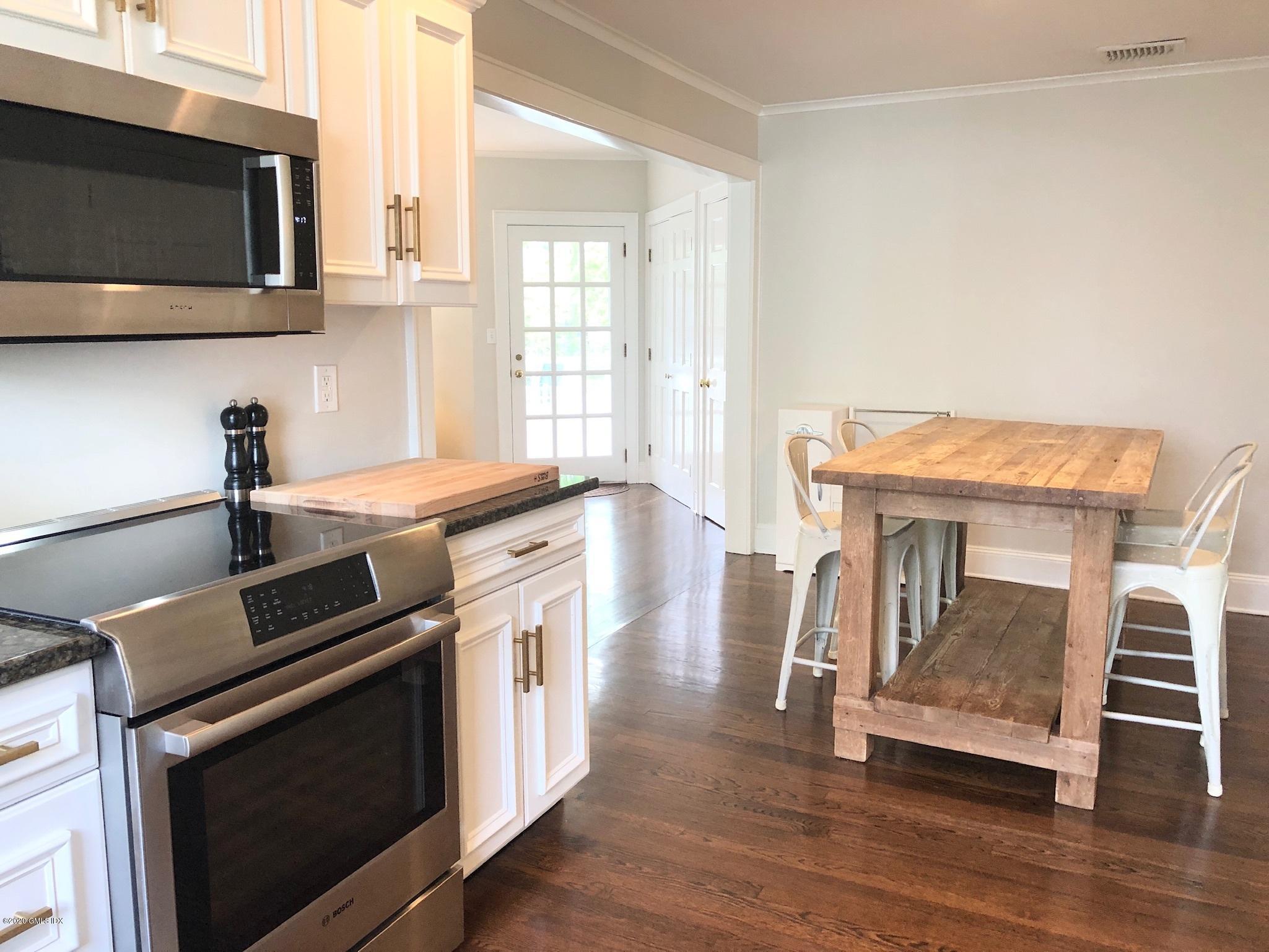 10 Lake Drive South, Unit SOUTH Riverside, CT 06878 - Photo 15 of 45 a kitchen with granite countertop a stove a microwave and wooden floor