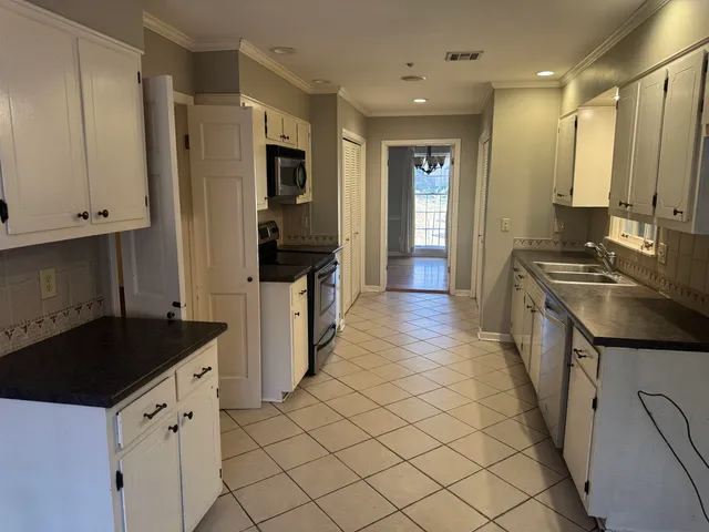 a kitchen with granite countertop a sink and a refrigerator