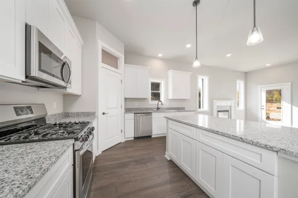 a large kitchen with stainless steel appliances granite countertop a stove and a sink