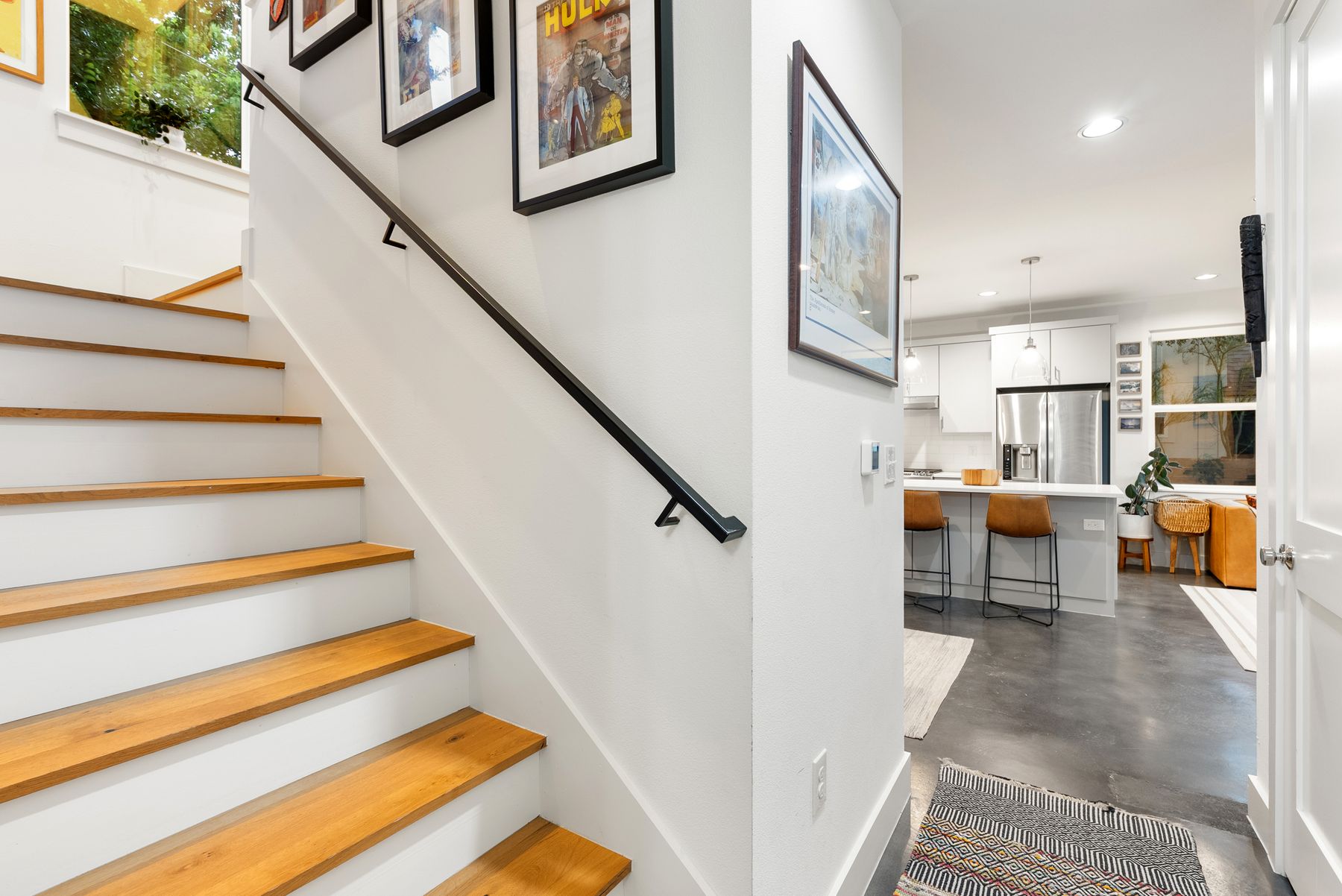 1709 Perez Street, Unit 2 Austin, TX 78721 - Photo 19 of 33 Hardwood steps lead to an open concept living space, anchored by a sleek, modern kitchen.