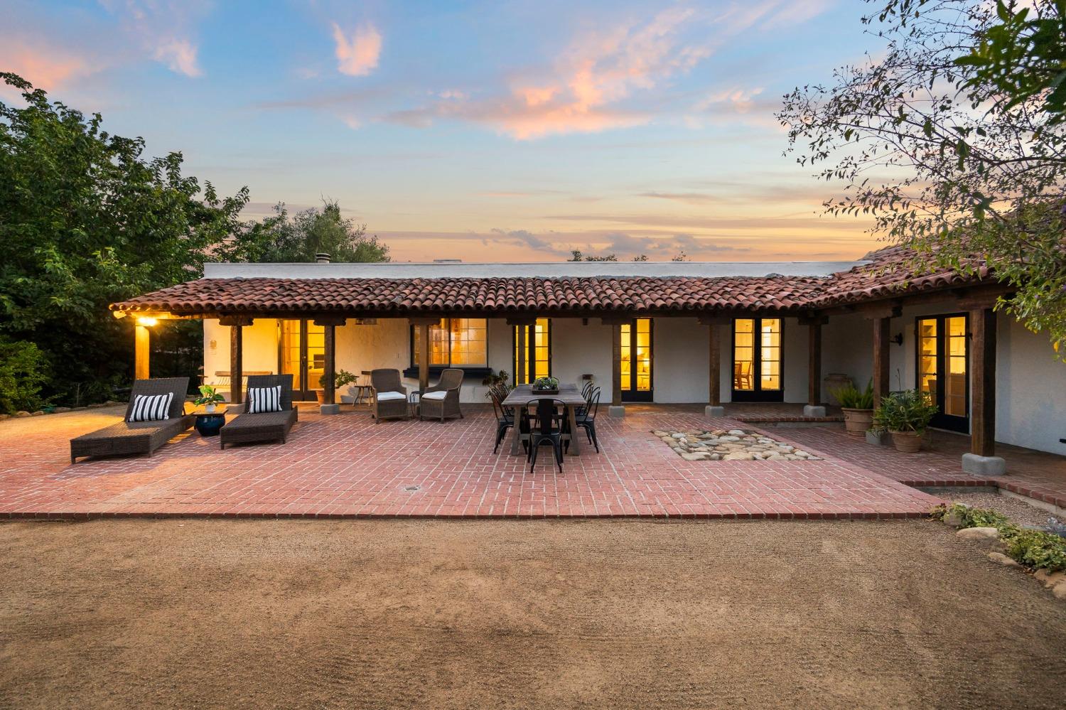 105 Foothill Road Ojai, CA 93023 - Photo 23 of 38 a view of a patio with table and chairs under an umbrella with large trees