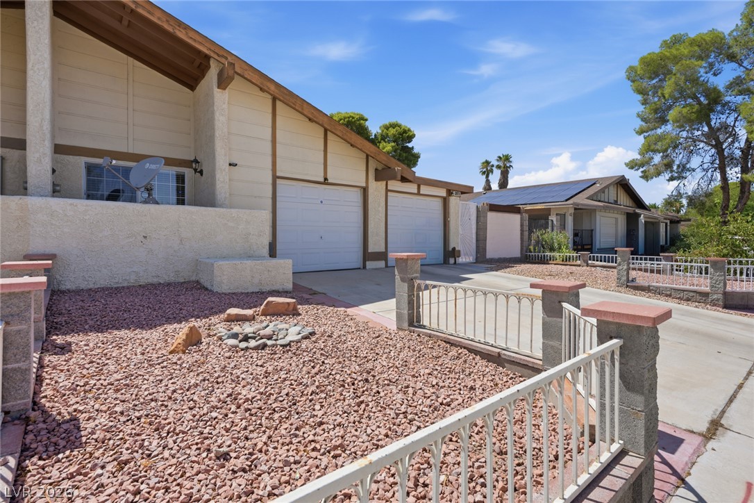 3971 Spring Leaf Drive Las Vegas, NV 89147 - Photo 9 of 48 Two attached garages and a xeriscaped front yard with a decorative rock garden.
