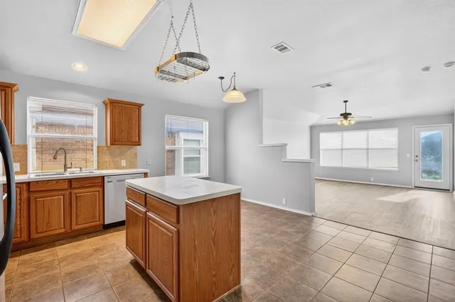 a kitchen with a stove a sink a refrigerator and chandelier