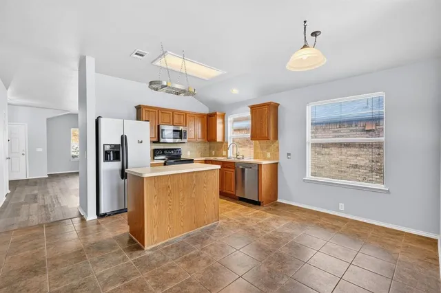 a kitchen with stainless steel appliances granite countertop a refrigerator and a sink