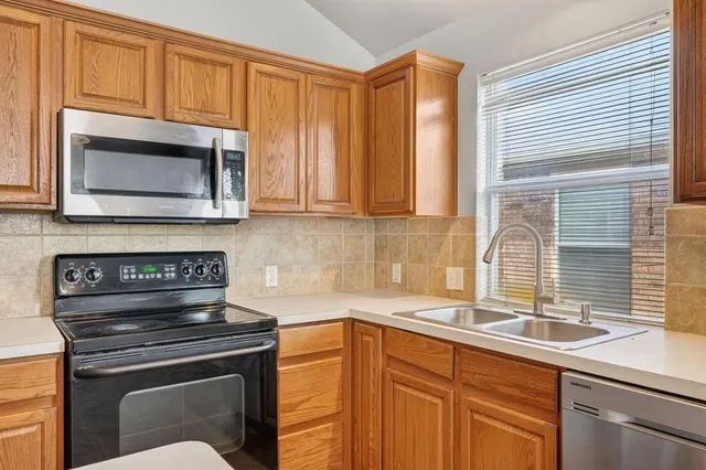 a kitchen with granite countertop a stove sink and microwave