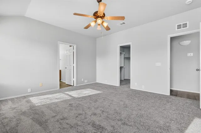 a view of an empty room with a ceiling fan