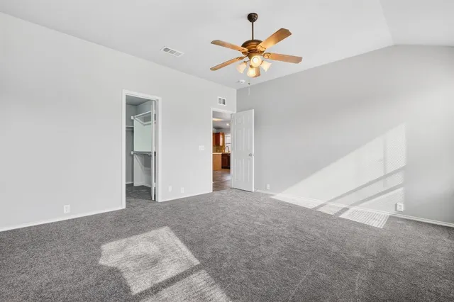 a view of an empty room with a chandelier fan
