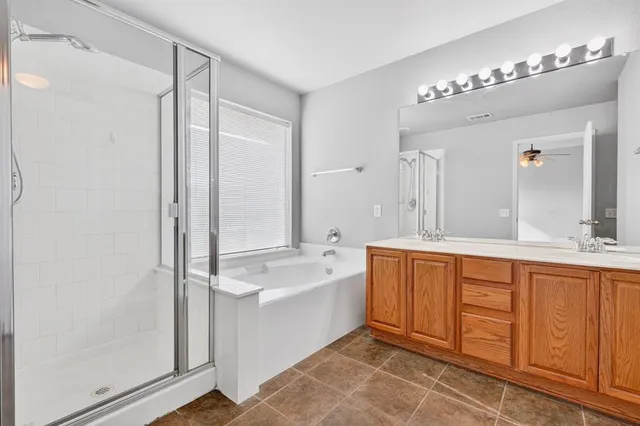 a spacious bathroom with a double vanity sink a mirror and a bathtub