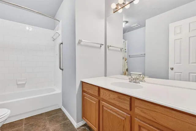 a bathroom with a granite countertop sink mirror toilet and bathtub