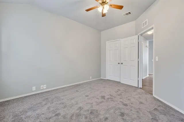 an empty room with a chandelier fan