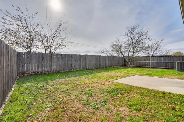 a view of a backyard with wooden fence