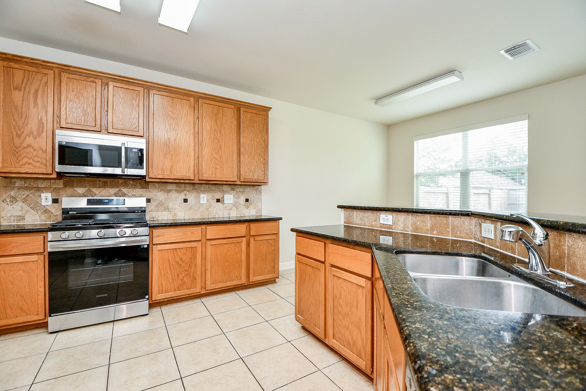 2707 Silk Tree Lane Katy, TX 77449 - Photo 11 of 31 a kitchen with stainless steel appliances granite countertop a stove sink and microwave