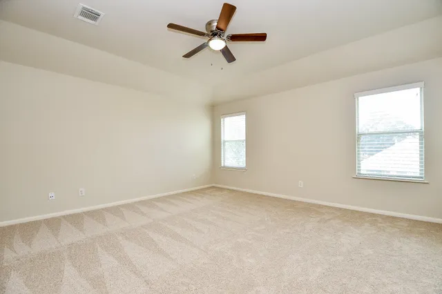 an empty room with a window and a fan