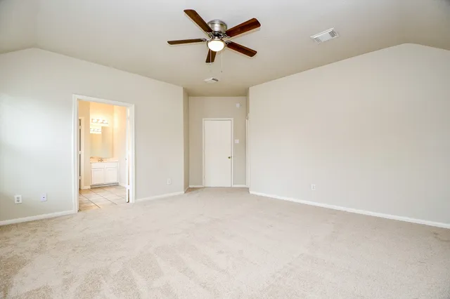 an empty room with closet and a ceiling fan