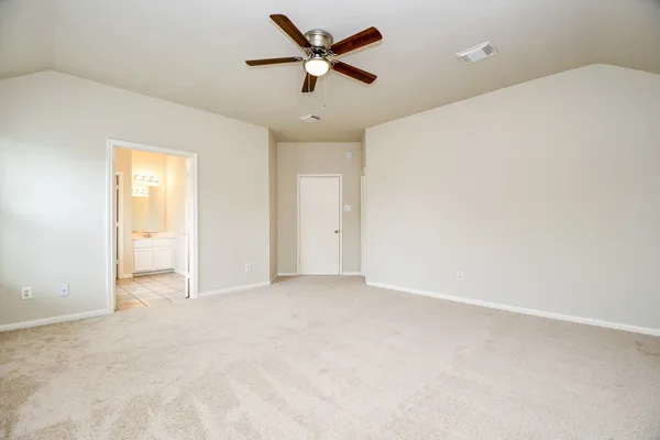 an empty room with closet and a ceiling fan