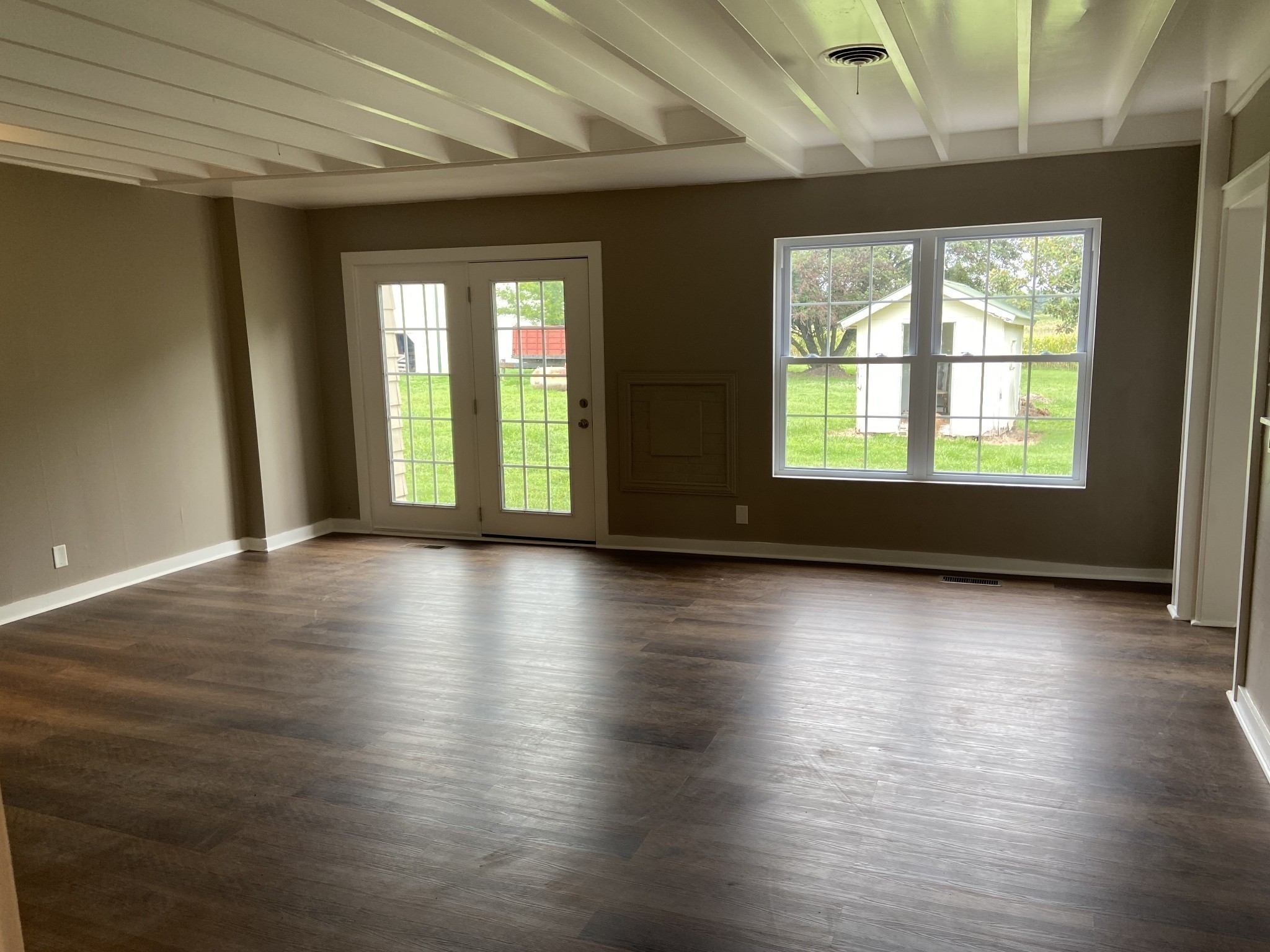11495 Guthrie Road Guthrie, KY 42234 - Photo 13 of 43 an empty room with wooden floor and windows with curtains