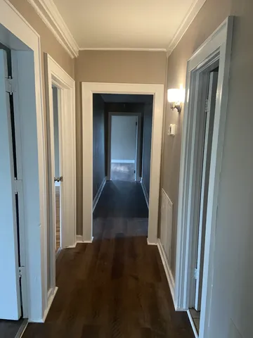 a view of a hallway with wooden floor and closet