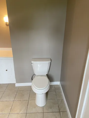 a white toilet sitting next to a shower