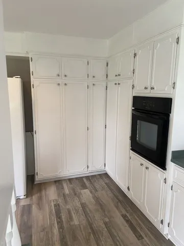 a view of a kitchen with wooden cabinet
