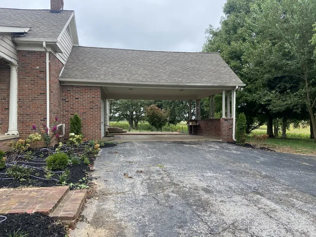 a view of a house with potted plants and large trees