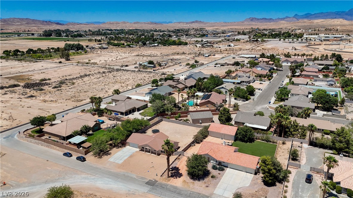 1272 Liston Avenue Logandale, NV 89021 - Photo 55 of 61 An aerial perspective reveals a quiet desert neighborhood nestled against a mountain range.