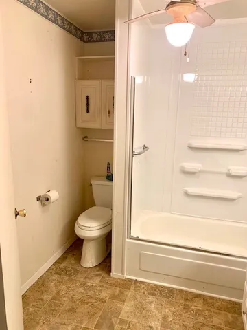 a bathroom with a toilet and a shower