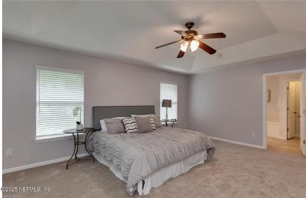 a bedroom with a large bed and a ceiling fan