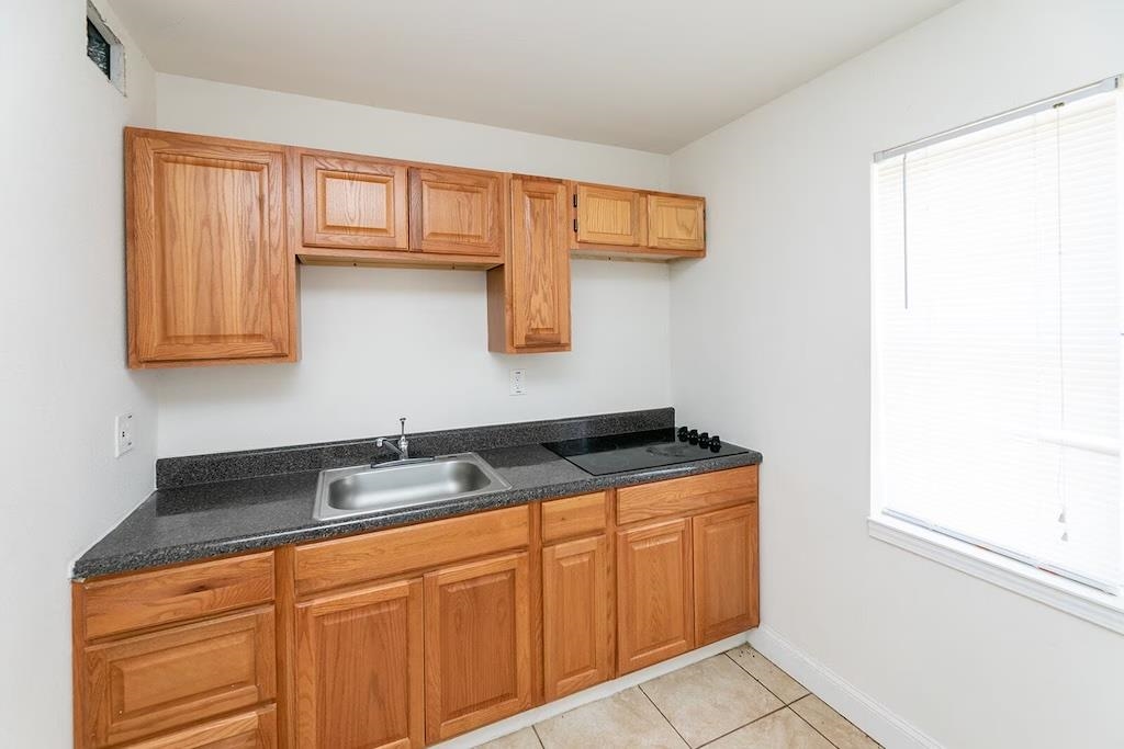 3236 Millington Road Memphis, TN 38127 - Photo 8 of 31 Kitchenette featuring wood cabinetry, stainless steel sink, dark countertop, and integrated cooktop