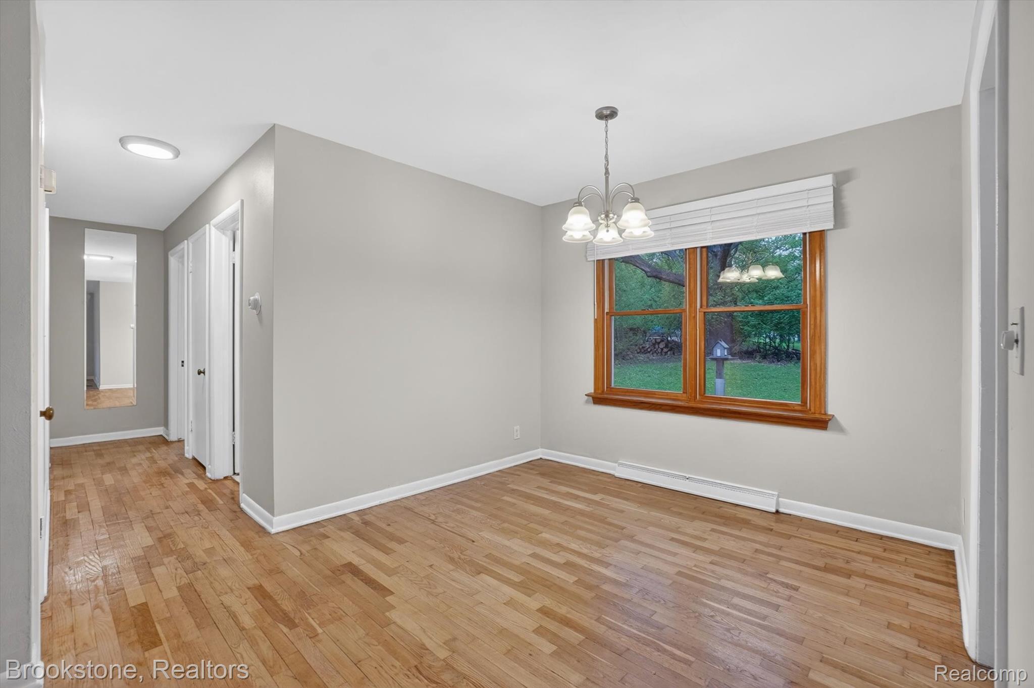 4547 Marlborough Road Okemos, MI 48864 - Photo 9 of 55 Unfurnished dining area with hanging lights, light wood-style floors, and baseboard heating