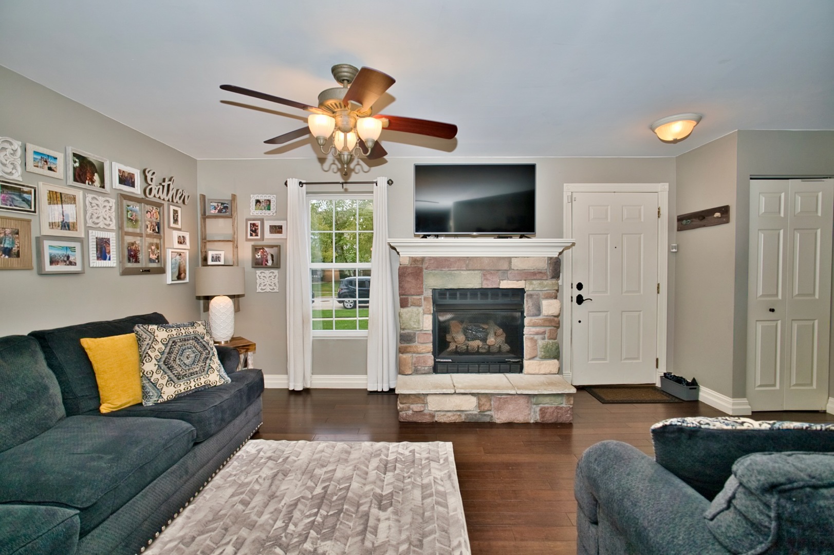 6313 Colton Ridge Court Plainfield, IL 60586 - Photo 5 of 57 a living room with furniture a flat screen tv and a fireplace