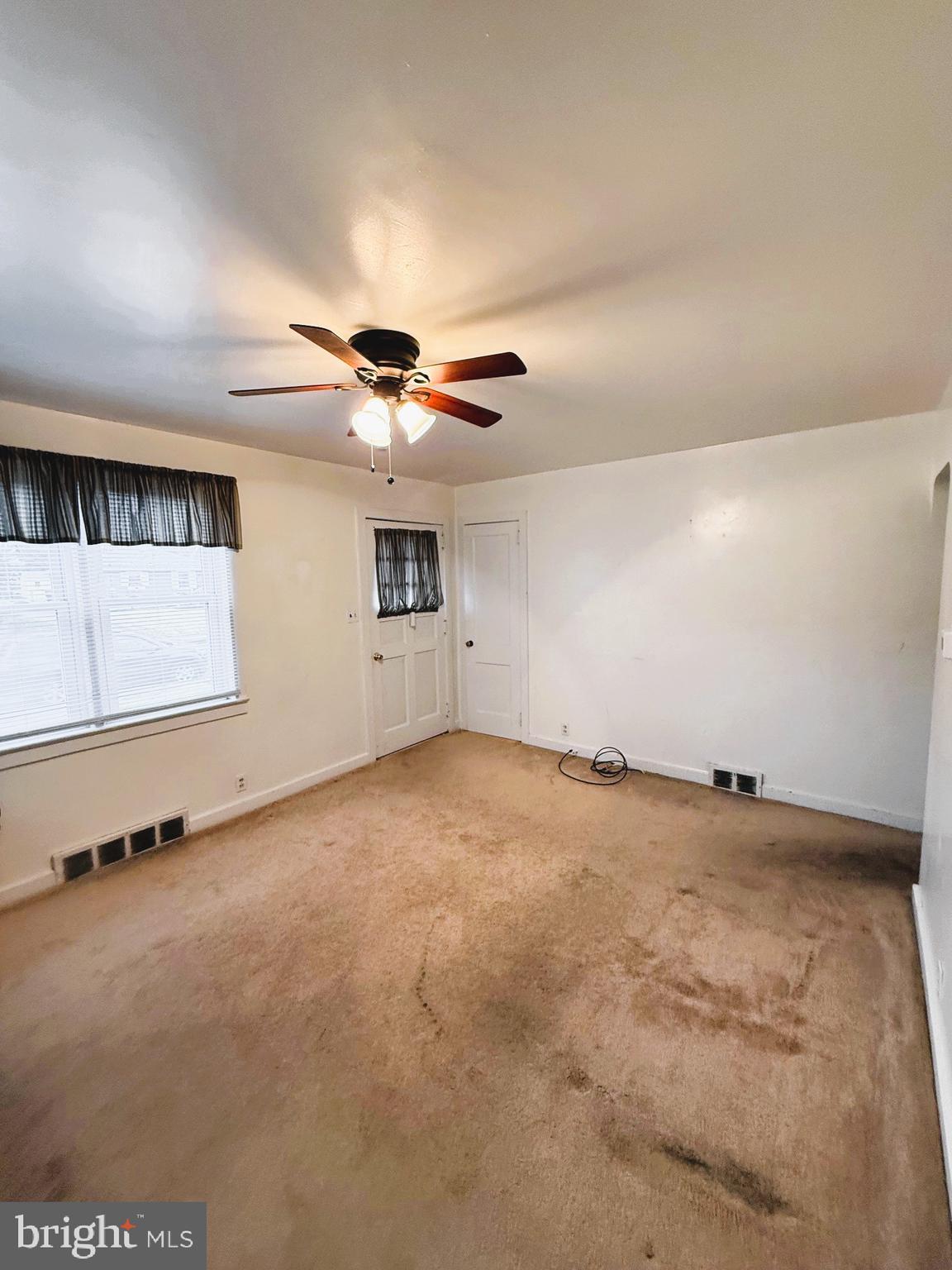18 Cornell Avenue Bridgeton, NJ 08302 - Photo 5 of 20 an empty room with a ceiling fan and window