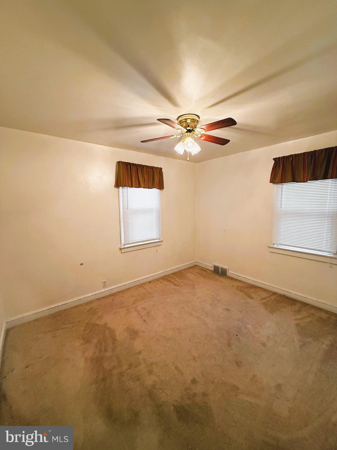 18 Cornell Avenue Bridgeton, NJ 08302 - Photo 8 of 20 an empty room with a ceiling fan and window