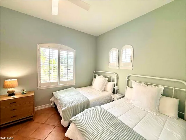 a bedroom with two beds and a window