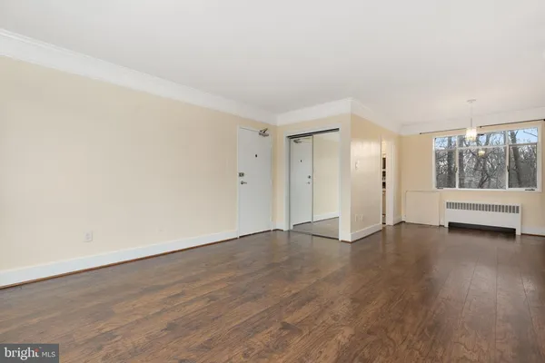a view of a room with wooden floor and window