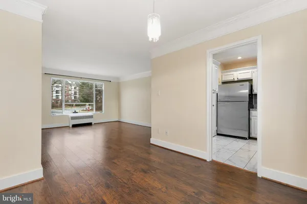 a view of a livingroom with wooden floor a ceiling fan and window