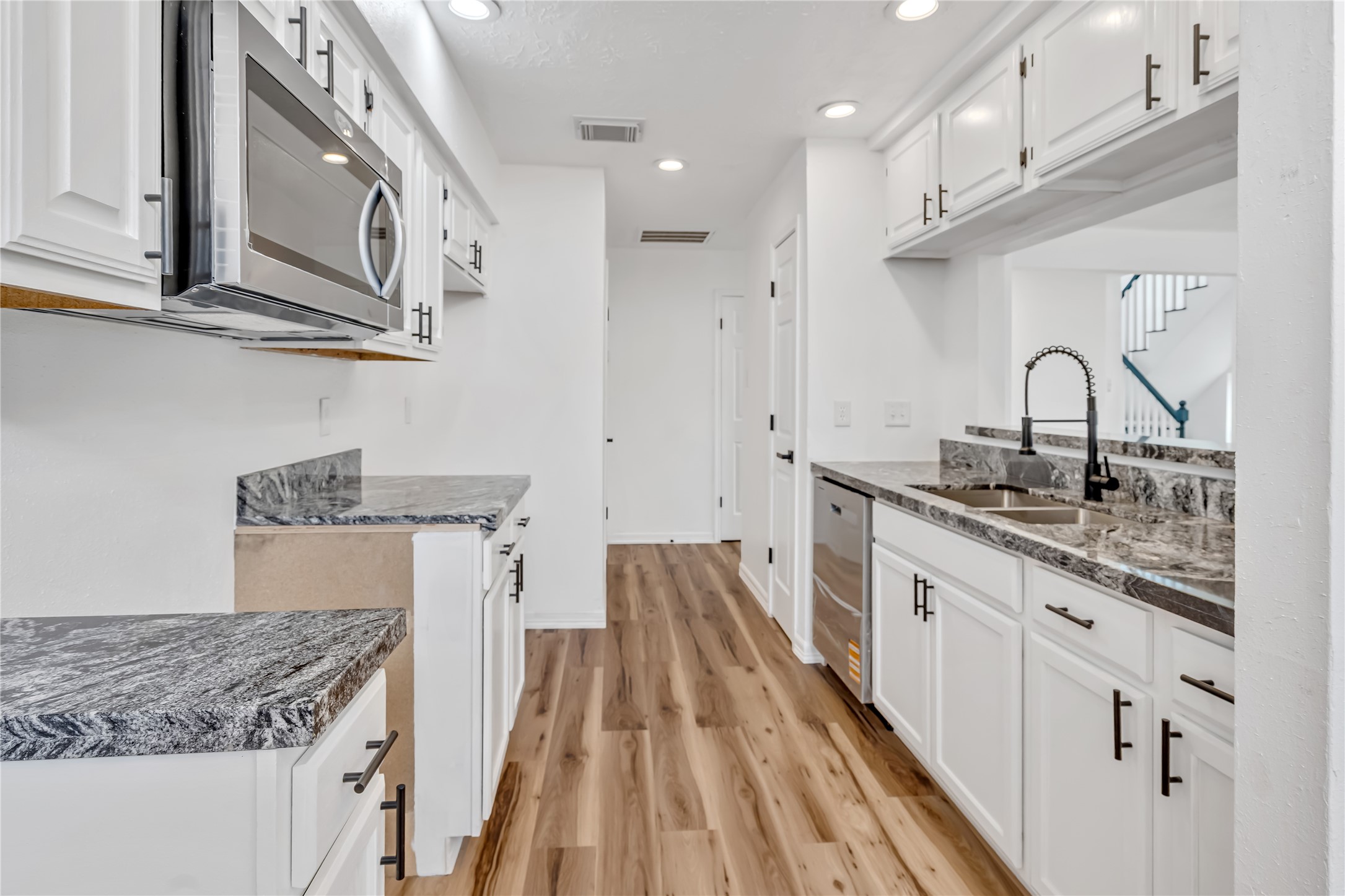 12426 North Rachlin Circle Houston, TX 77071 - Photo 27 of 31 a kitchen with stainless steel appliances granite countertop a lot of counter space and wooden floors