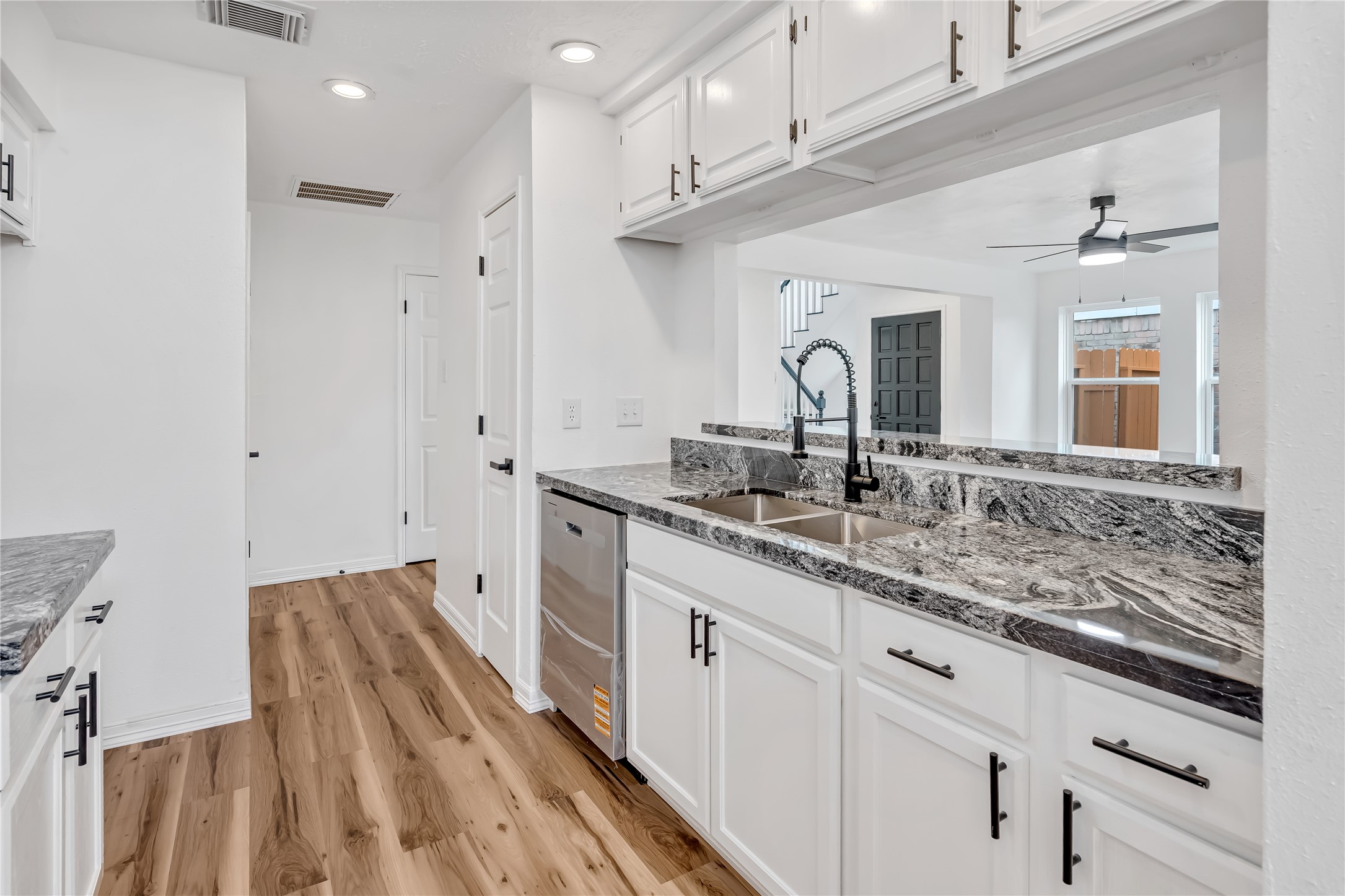 12426 North Rachlin Circle Houston, TX 77071 - Photo 28 of 31 a hall with kitchen island a sink stainless steel appliances and cabinets