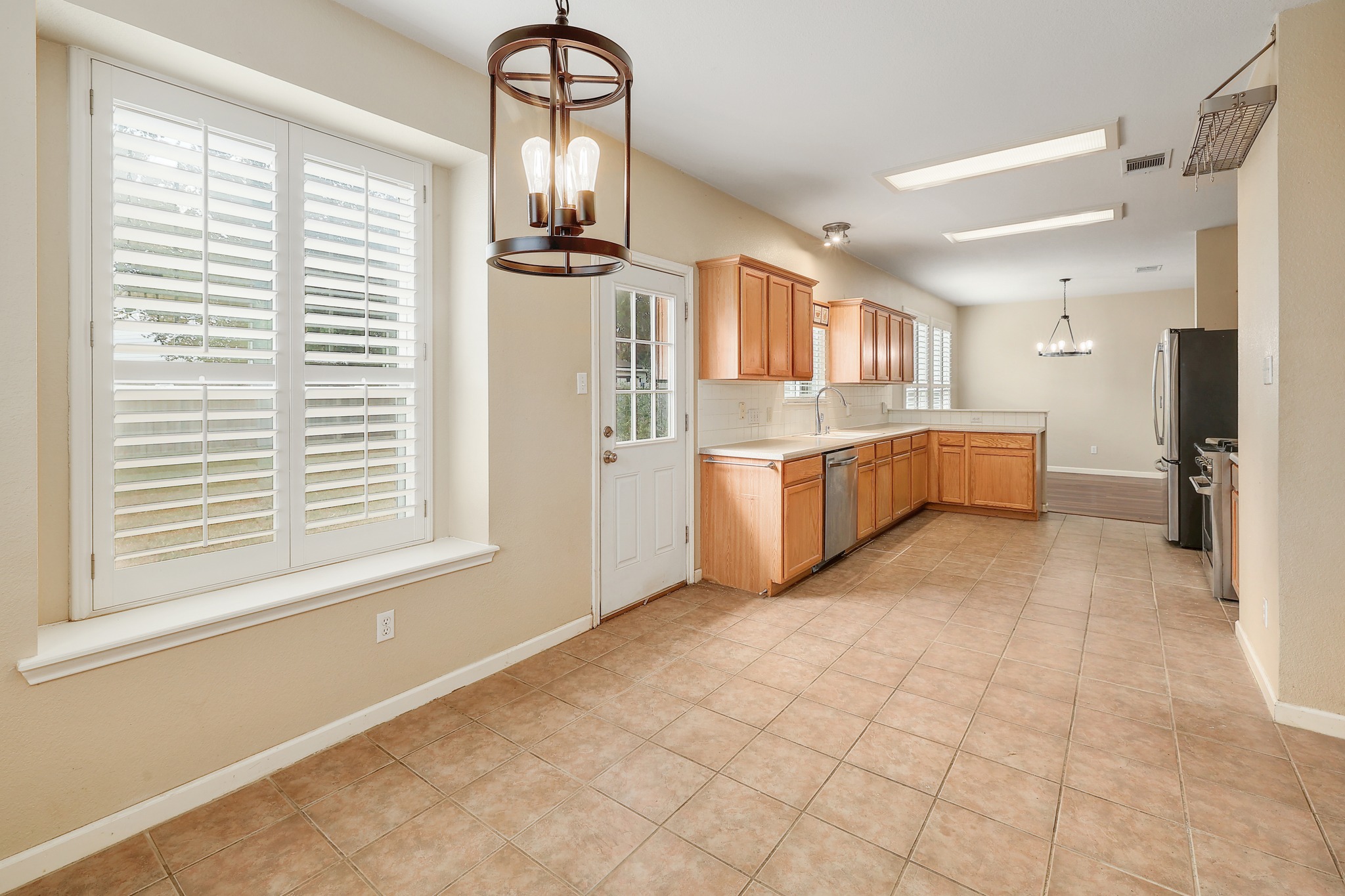 4615 Tello Path Austin, TX 78749 - Photo 13 of 31 Tiled flooring and warm wood cabinetry define this functional kitchen and dining layout.