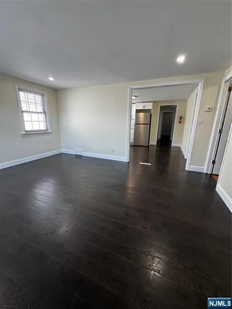 an empty room with wooden floor and cabinet