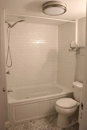 a bathroom with a shower a toilet and a shower
