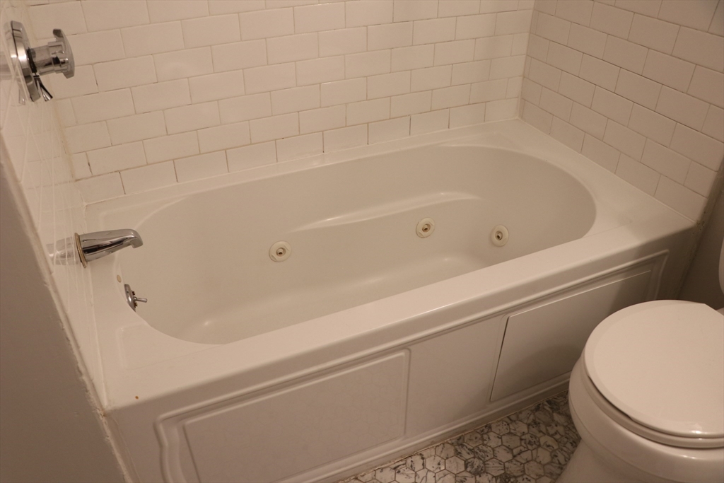 320 Warren Street, Unit 2 Boston, MA 02119 - Photo 14 of 22 a bathroom with a bathtub and toilet