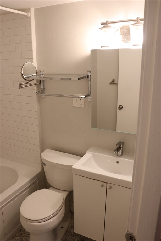320 Warren Street, Unit 2 Boston, MA 02119 - Photo 15 of 22 a white toilet sitting next to a bathroom sink